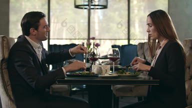 浪漫的夫妇吃餐厅男人。给食物女人浪漫的晚餐